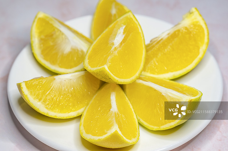 大理石台面上一碟黄色的橘子图片素材