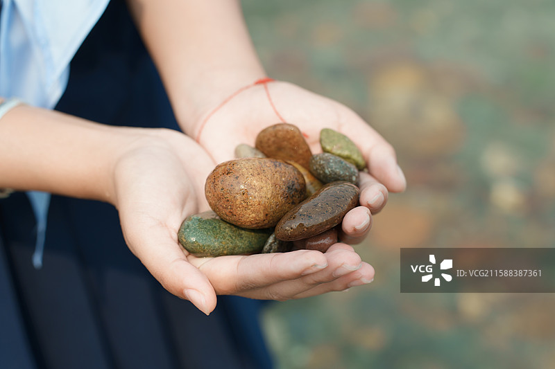 手中多彩鹅卵石图片素材