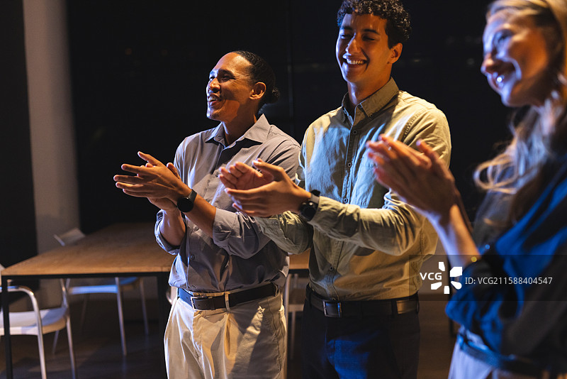 商务专业人士在晚间会议中鼓掌，表达喜悦和成功。图片素材