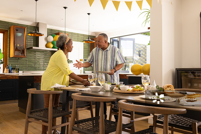 在现代厨房里享用早餐的非裔美国老年夫妇温暖地微笑图片素材