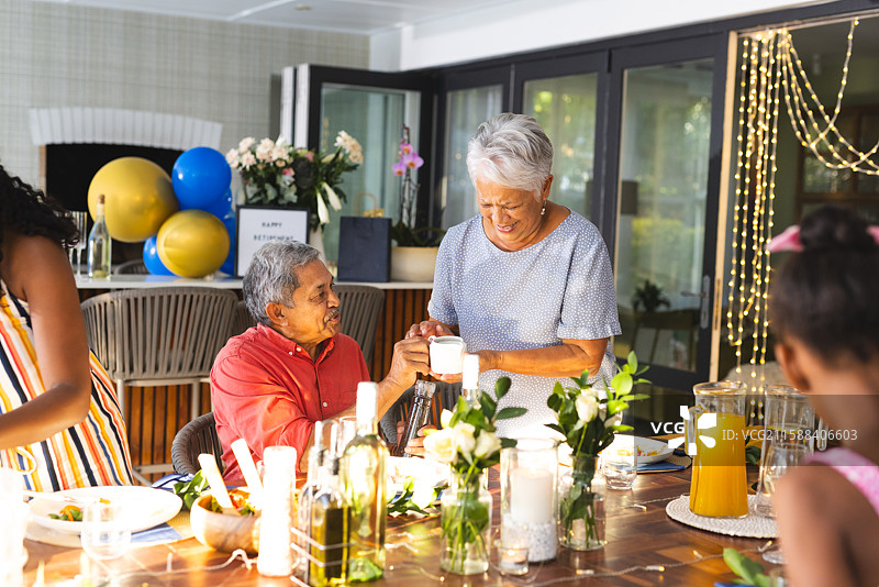 庆祝生日，老年夫妇与家人在户外聚会中共享欢笑图片素材