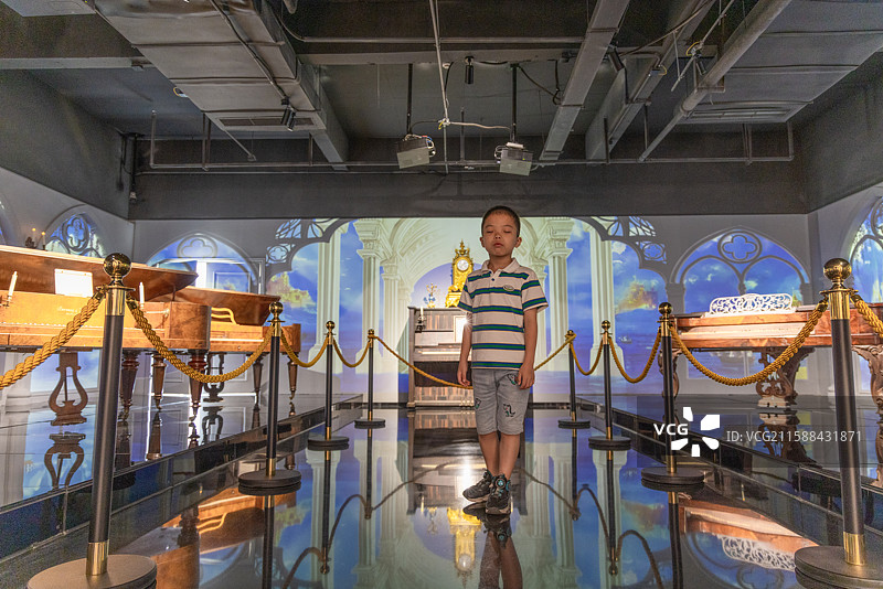小男孩在成都芯智慧音乐博物馆里参观各种乐器图片素材