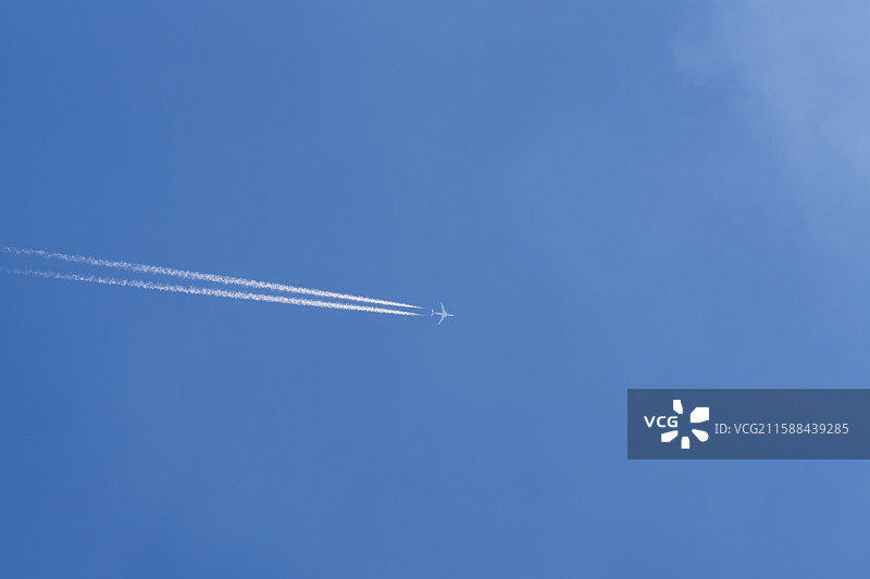 蓝色天空上的喷气机和飞机云图片素材