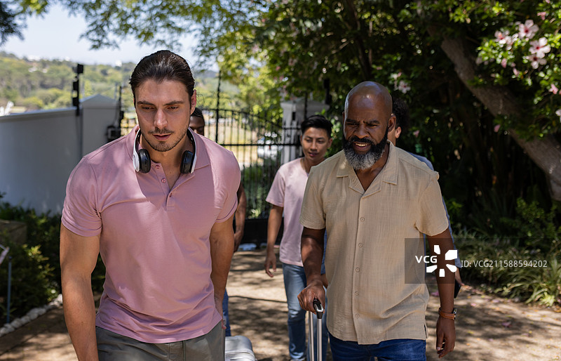 一群男人在户外走动，准备在阳光明媚的天空下举行婚礼活动图片素材