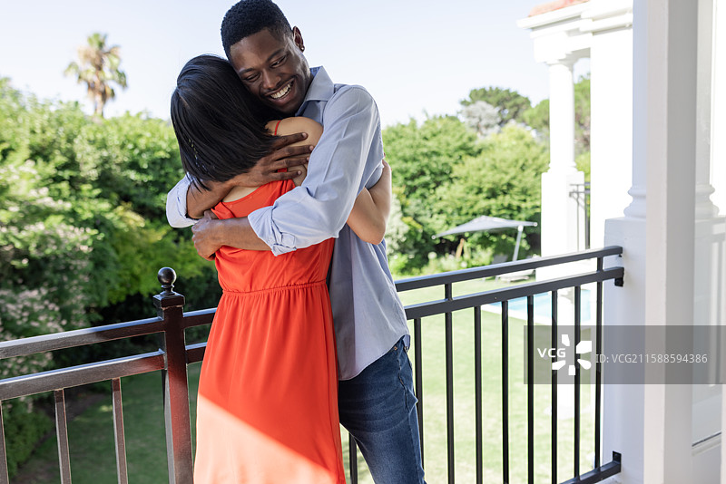 情侣在阳台上相拥，享受户外婚礼场地的阳光明媚日子图片素材