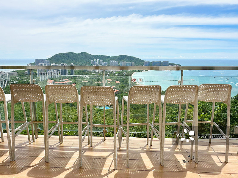 海滩上的空椅子和桌子远眺上城市风光中国海南省三亚市自贸风光鹿回头风景区4A景点公园背景暑假图片素材