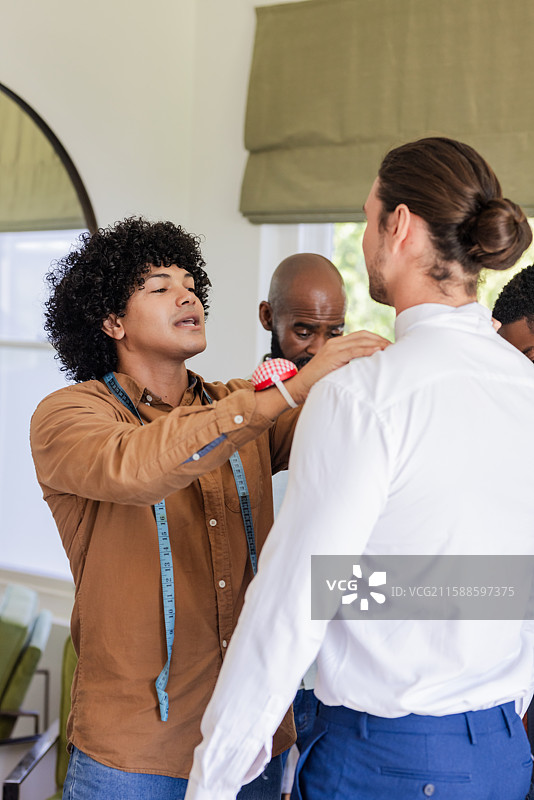 裁缝专注而细心地调整新郎的西装，为婚礼仪式做准备图片素材