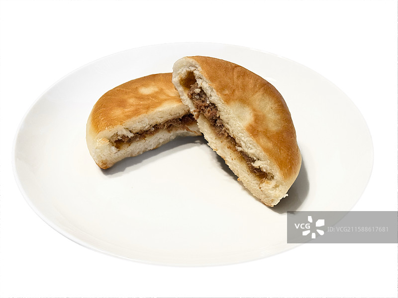 白色瓷盘上对半切开的牛肉馅饼高视角视图图片素材