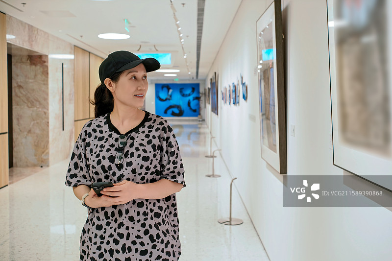 女子在画廊内观赏艺术作品图片素材