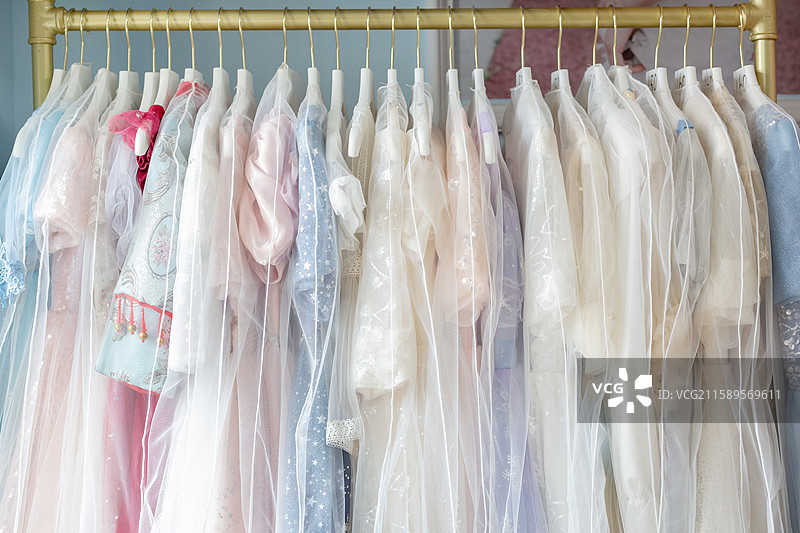 衣架上挂着的一排不同色彩的儿童礼服图片素材