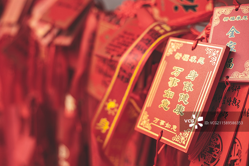 中国道教宗教象征传统文化拍摄主题  ,铁栏杆子上悬挂着大量万事如意身体健康许愿牌子，户外白昼无人图像图片素材