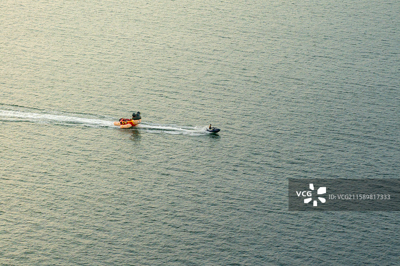 航拍烟台金沙滩景区海面上的被快速拖行的卡通游船图片素材