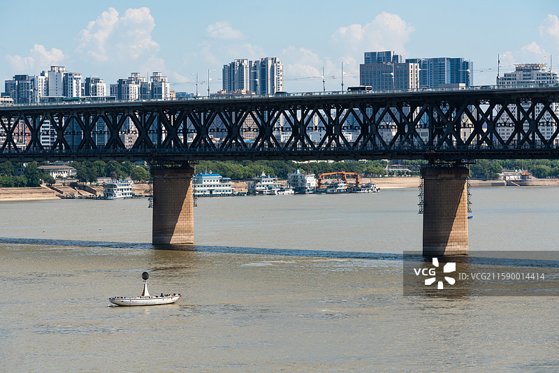 湖北武汉有一艘船漂浮在桥下水中图片素材