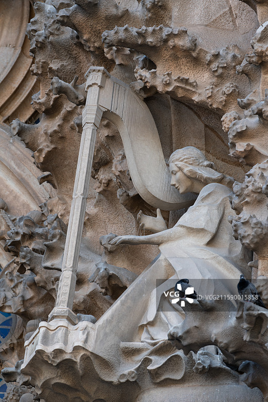 西班牙巴塞罗那建筑物上弹奏竖琴阿拉菲德女图片素材
