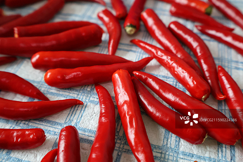 格子桌布上的小米辣红色辣椒特写图片素材