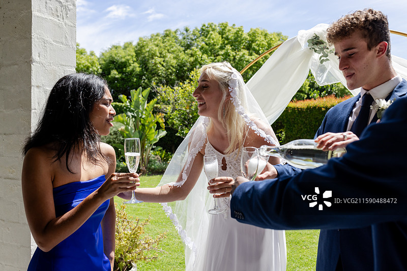 新娘在户外婚礼庆祝活动中与宾客分享香槟图片素材