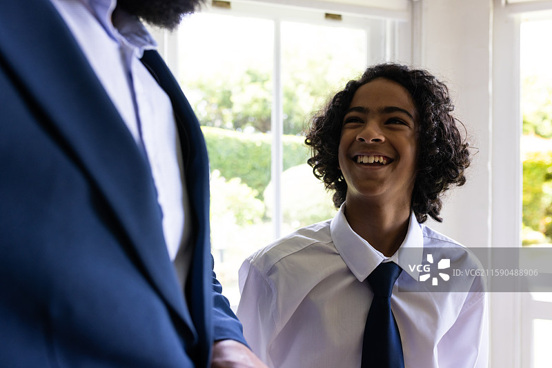 年轻男孩身穿正式服装，在室内欢快地微笑庆祝成人礼图片素材