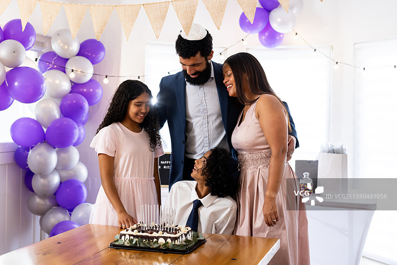 家庭在家中一起庆祝成人礼，享用蛋糕和装饰品图片素材