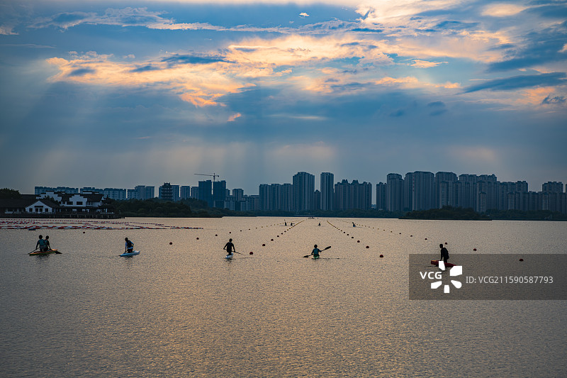 湖畔夕阳下的桨板运动者图片素材