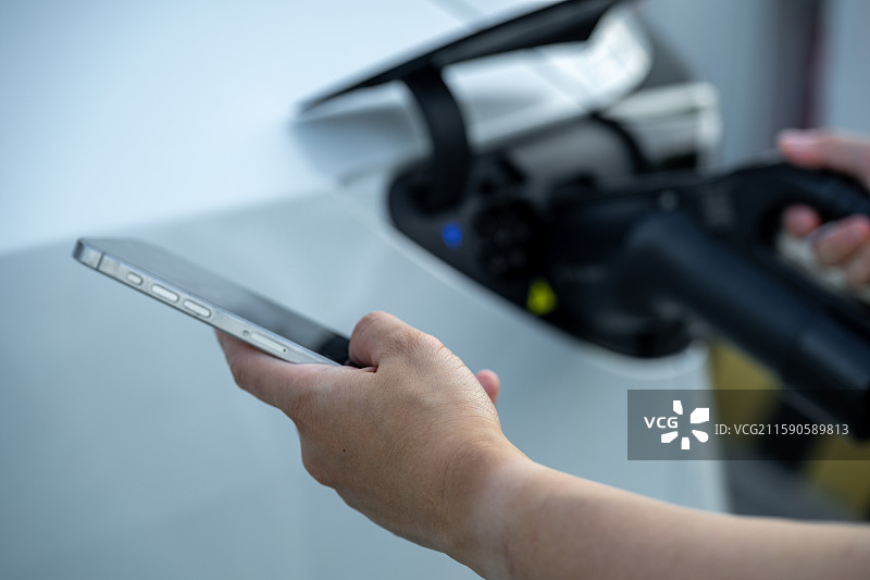 使用手机控制电动汽车充电图片素材