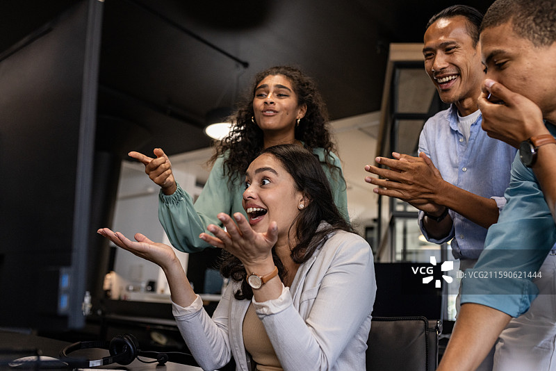 多元化的商业团队在现代办公室环境中共同庆祝成功图片素材