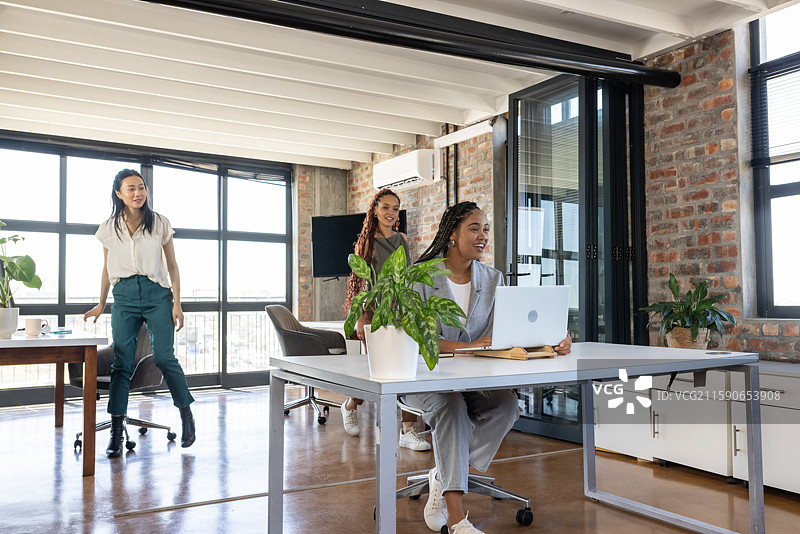 同事们在现代办公室庆祝成功，微笑着享受团队合作。图片素材