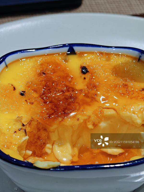 蓝边白碗里的焦糖布丁图片素材