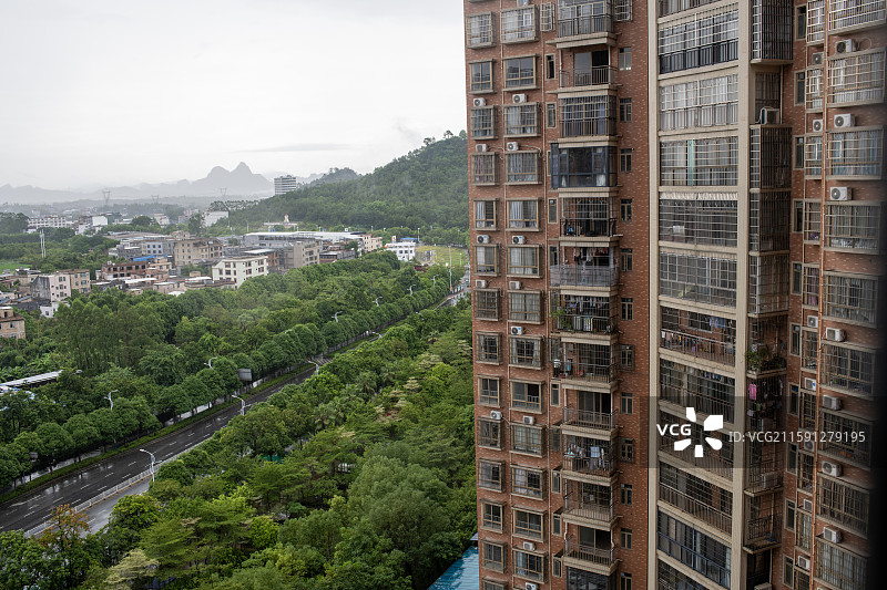 阴雨天气中的居民小区楼房，朦胧雨幕笼罩静谧生活氛围。图片素材