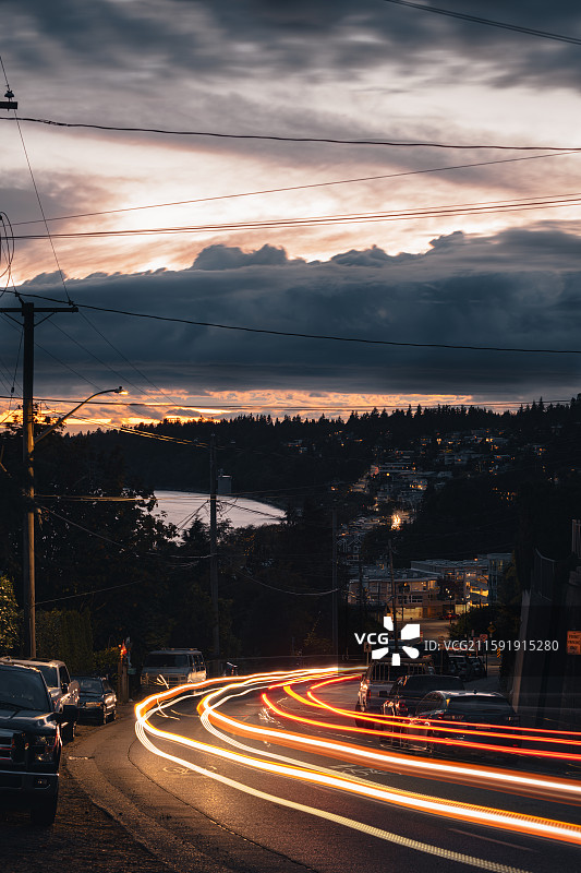 汽车驶过落日后海边小路形成的光轨图片素材