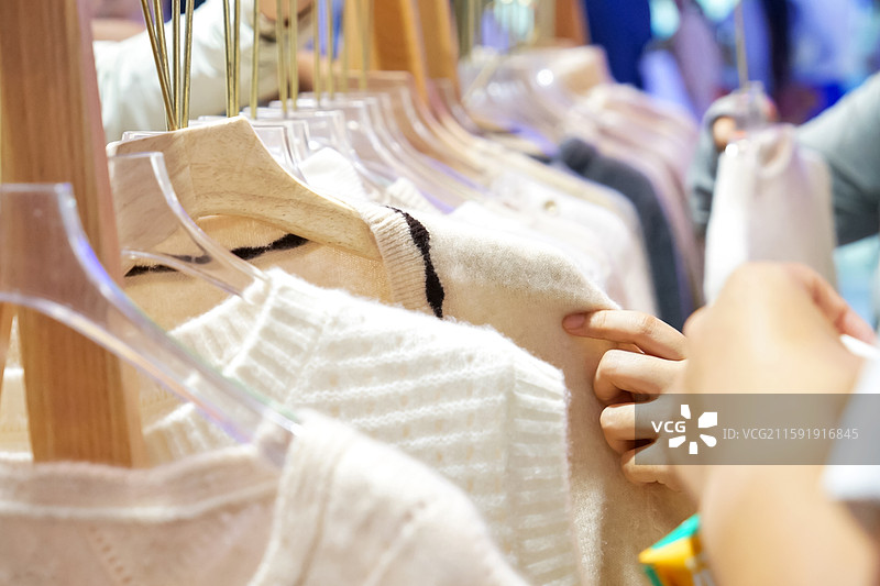 在商店里挑选衣服的女人的手图片素材