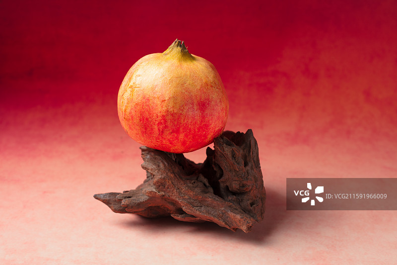 红石榴置于古朴木座上图片素材