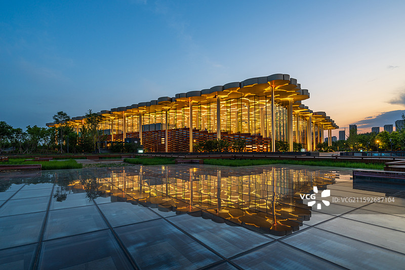 北京市通州区，城市副中心三大建筑之一：北京城市图书馆夜景内透，玻璃地面反射出建筑倒影。图片素材