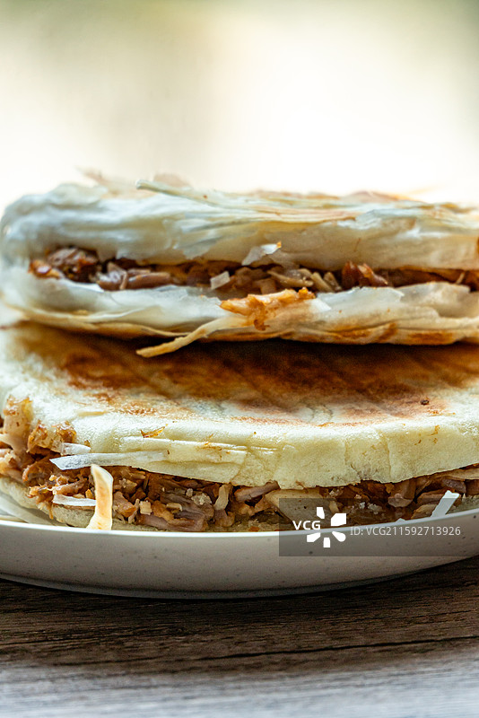 绿色虚化背景中的传统美食面食酥皮肉夹馍老面肉夹馍腊汁肉夹馍特写镜头图片素材