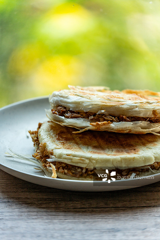绿色虚化背景中的传统美食面食酥皮肉夹馍老面肉夹馍腊汁肉夹馍特写镜头图片素材