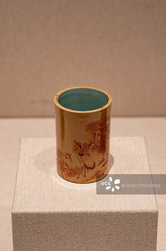 深圳博物馆展示的清代乾隆年间文物米色釉红彩松鹤纹笔筒图片素材