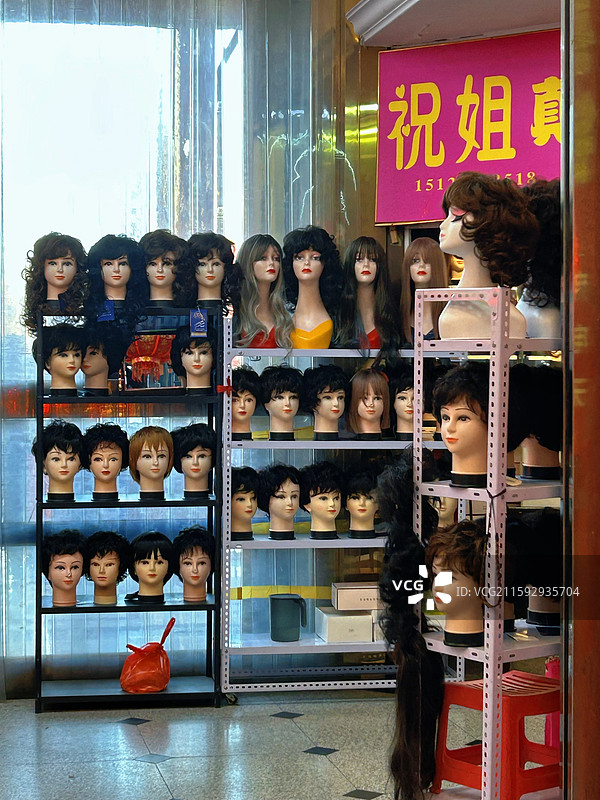 天津：商店里陈列着发型师培训用的模特头、假发图片素材