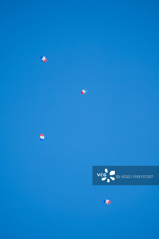 在晴朗的蓝天下跳伞的低角度视角图片素材