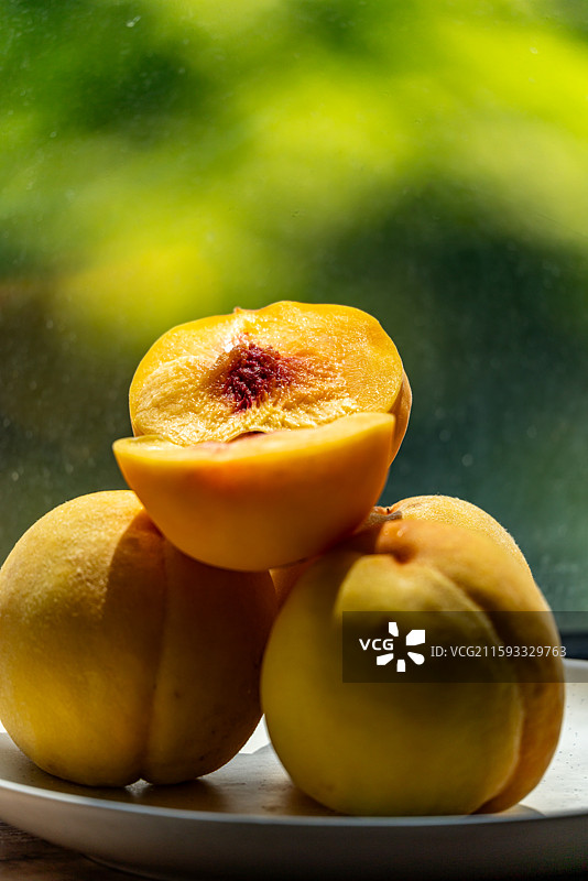 绿色虚化背景中的中国地理标志水果蒙阴黄桃.黄桃水果的果肉切面特写镜头图片素材