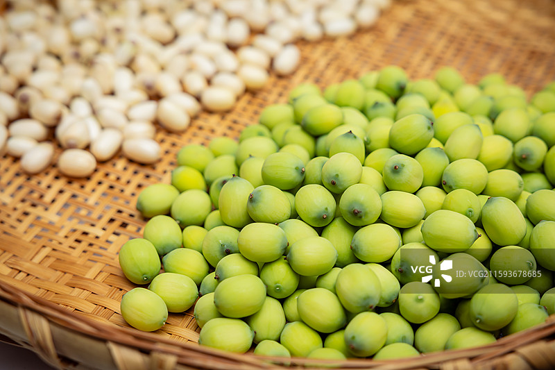 夏天 新鲜的莲子 现剥皮的莲子仁  莲蓬 干货 晾晒摆放在竹编圆簸箕 竹编托盘上特写图片素材