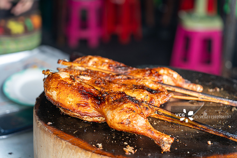 木制砧板上正宗的泰式烧烤鸡肉图片素材