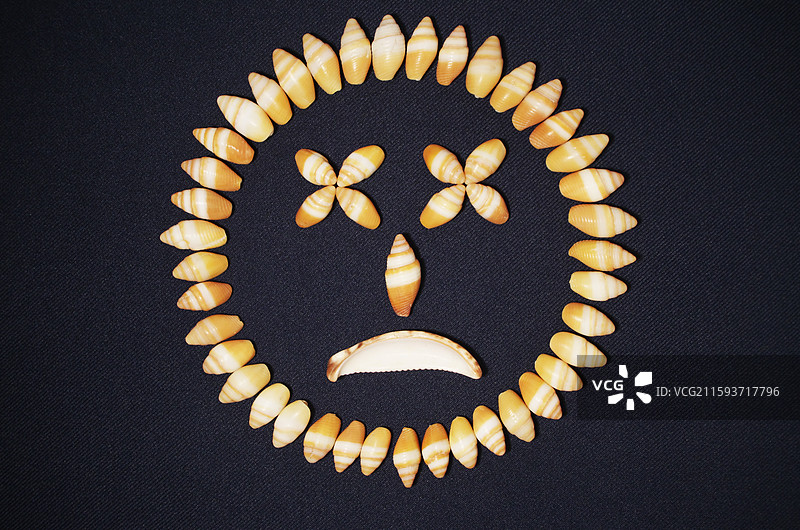 海螺壳贝壳组成人脸表情图案，哭脸悲伤不开心不高兴，素材背景，创意静物特写，抽象图案符号概念观念图片素材