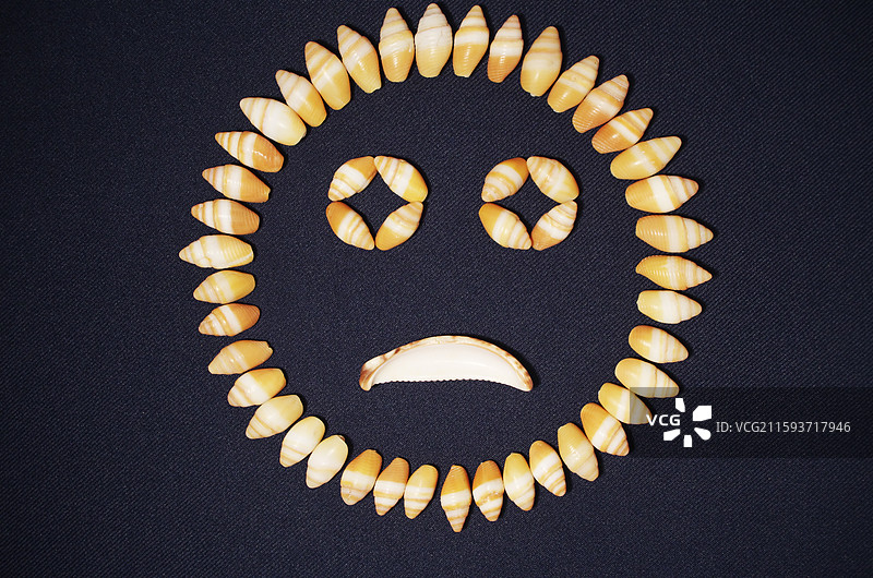 海螺壳贝壳组成人脸表情图案，哭脸悲伤不开心不高兴，素材背景，创意静物特写，抽象图案符号概念观念图片素材