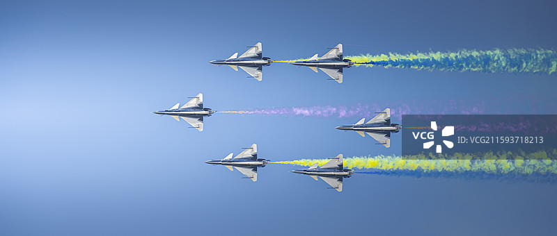 歼10飞机机群在蓝天下拉烟飞行的低角度视图图片素材