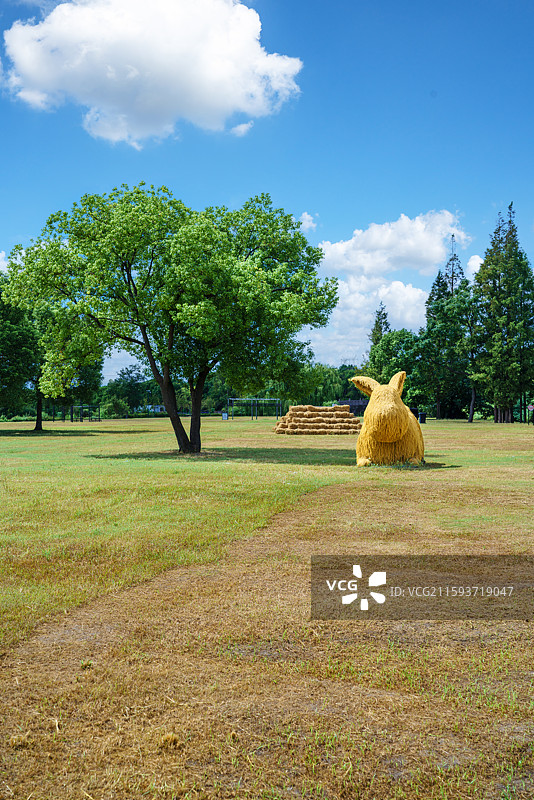 户外公园远处的一棵树和兔子玩偶稻草垛图片素材