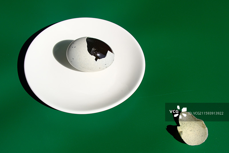 阳光下。绿色白色背景下盘子里的松花蛋。皮蛋。特写。设计素材图片素材