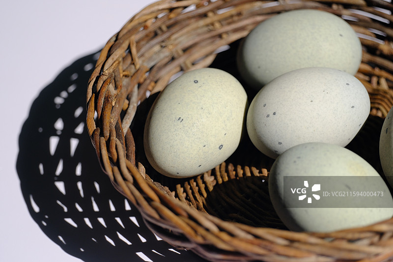 白色背景下。柳编筐里的松花蛋。皮蛋。绿色野草。设计素材科普图图片素材