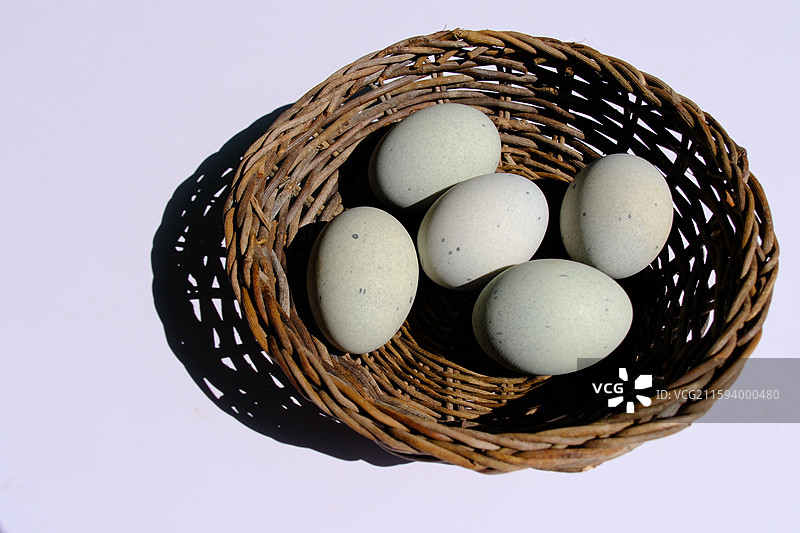 白色背景下。柳编筐里的松花蛋。皮蛋。绿色野草。设计素材科普图图片素材