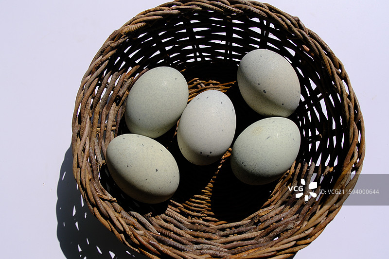 白色背景下。柳编筐里的松花蛋。皮蛋。绿色野草。设计素材科普图图片素材