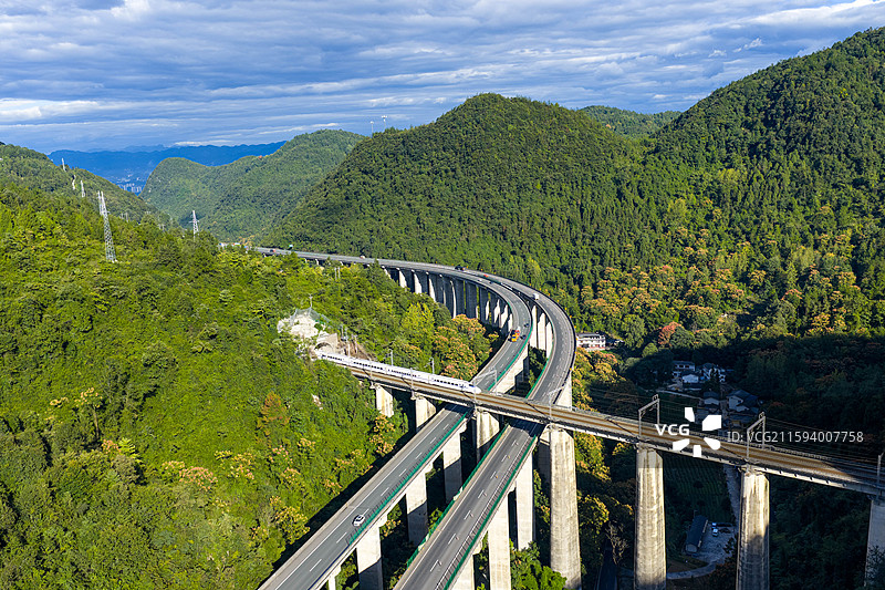 航拍沪渝高速与宜万铁路在湖北恩施市白果乡交汇一列高铁从高架桥上过境图片素材