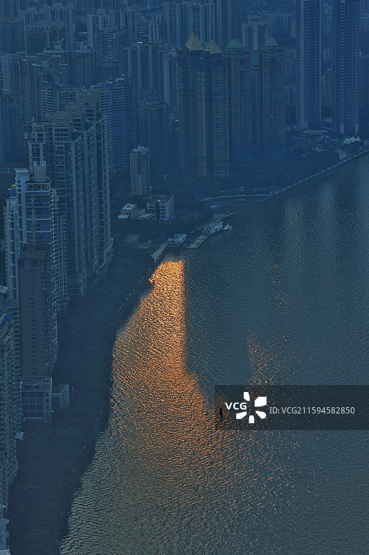 高楼一个劲的往天上长，但也拦不住夕阳把余晖匀给江水。天地间被这束光抱住，独一无二的剪影。图片素材